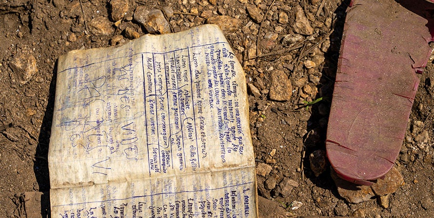 A tattered notebook and a ripped footware on the ground in Syria