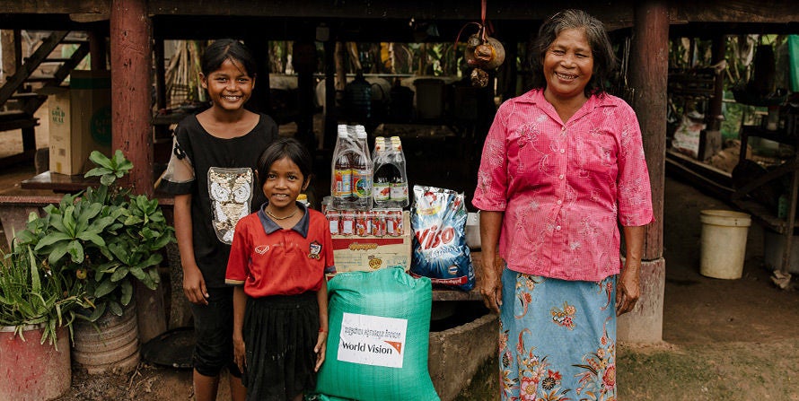 Happy mom with two daughter's receive food basket  